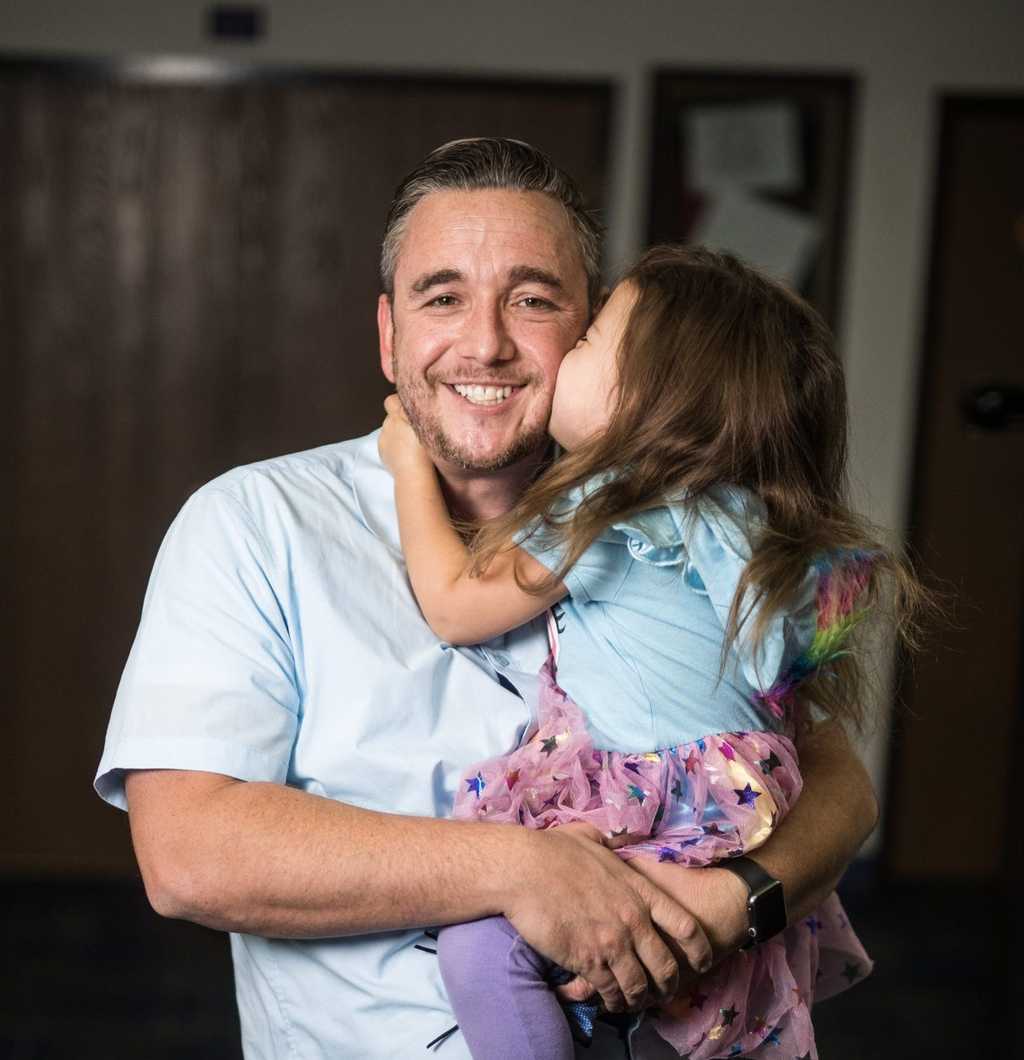 Young girl kissing her father on the cheek