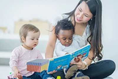 Woman reading a book to 2 toddlers